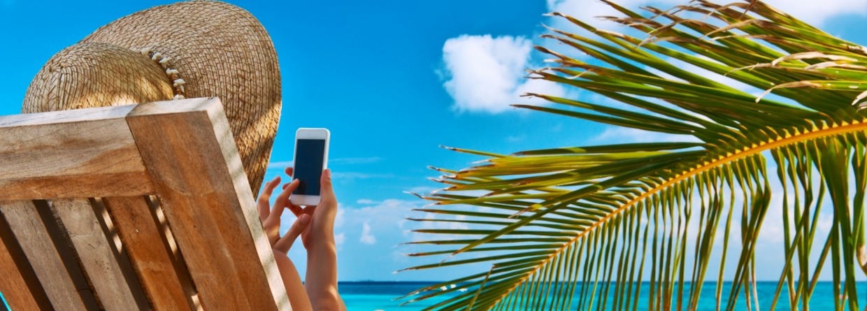 Vrouw in strandstoel met mobiel
