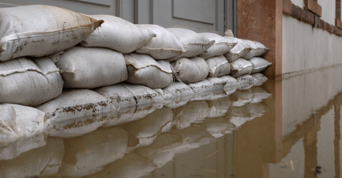 Hoog water; zandzakken voor de woning