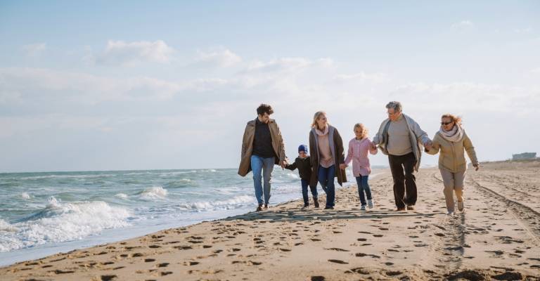 Gezin aan het strand in de herfst